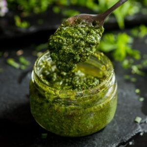 The Outdoor Apothecary chickweed pesto in a jar with a spoon